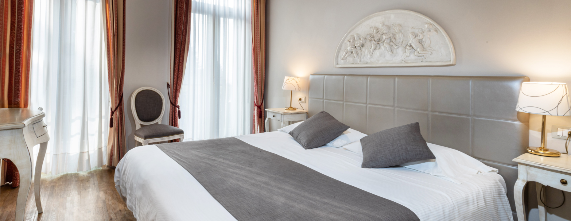 Elegantes Zimmer mit Doppelbett und klassischer Dekoration.